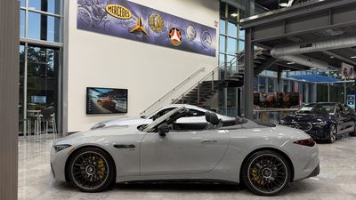 An AMG SL roadster on the main floor, heritage mural behind