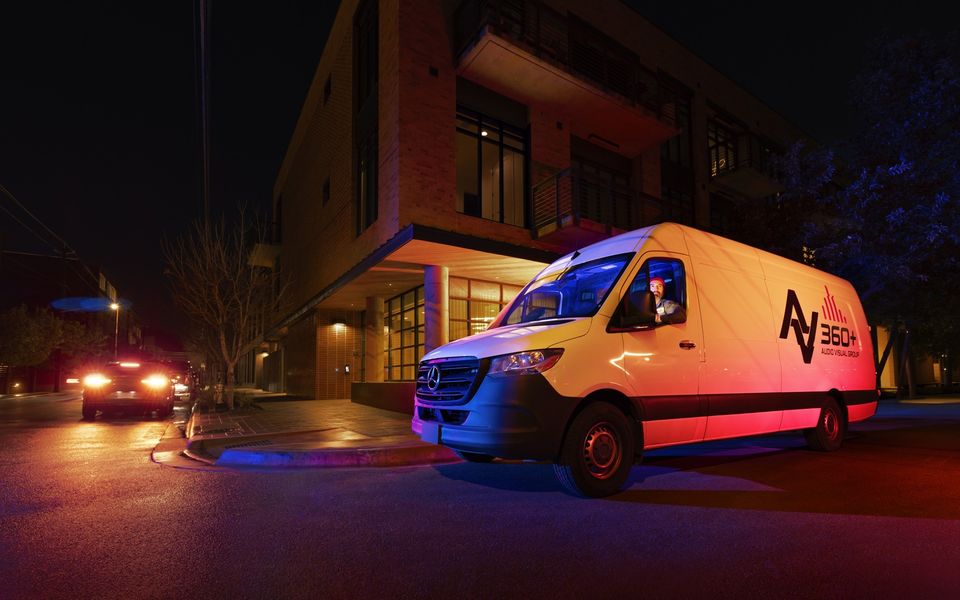 Branded Sprinter Cargo Van parked at night