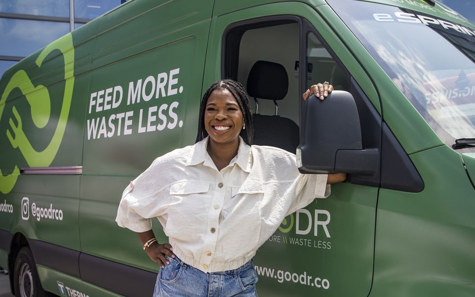 Team member beside a branded green Sprinter van