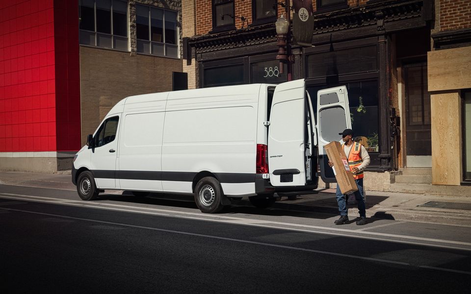 Courier at the side door of a high-roof Sprinter Cargo Van